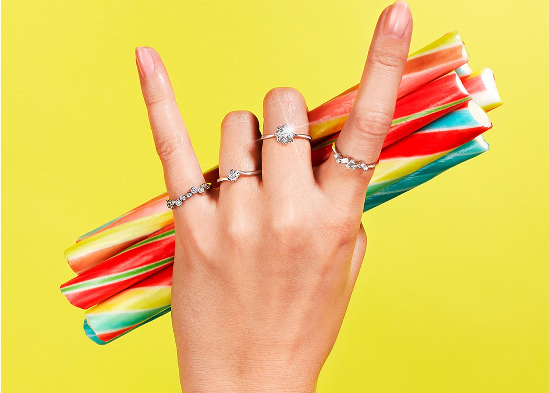 How Your Jewellery Channels Your Vibe? Rock on hand symbol wearing diamond rings and holding rock candy